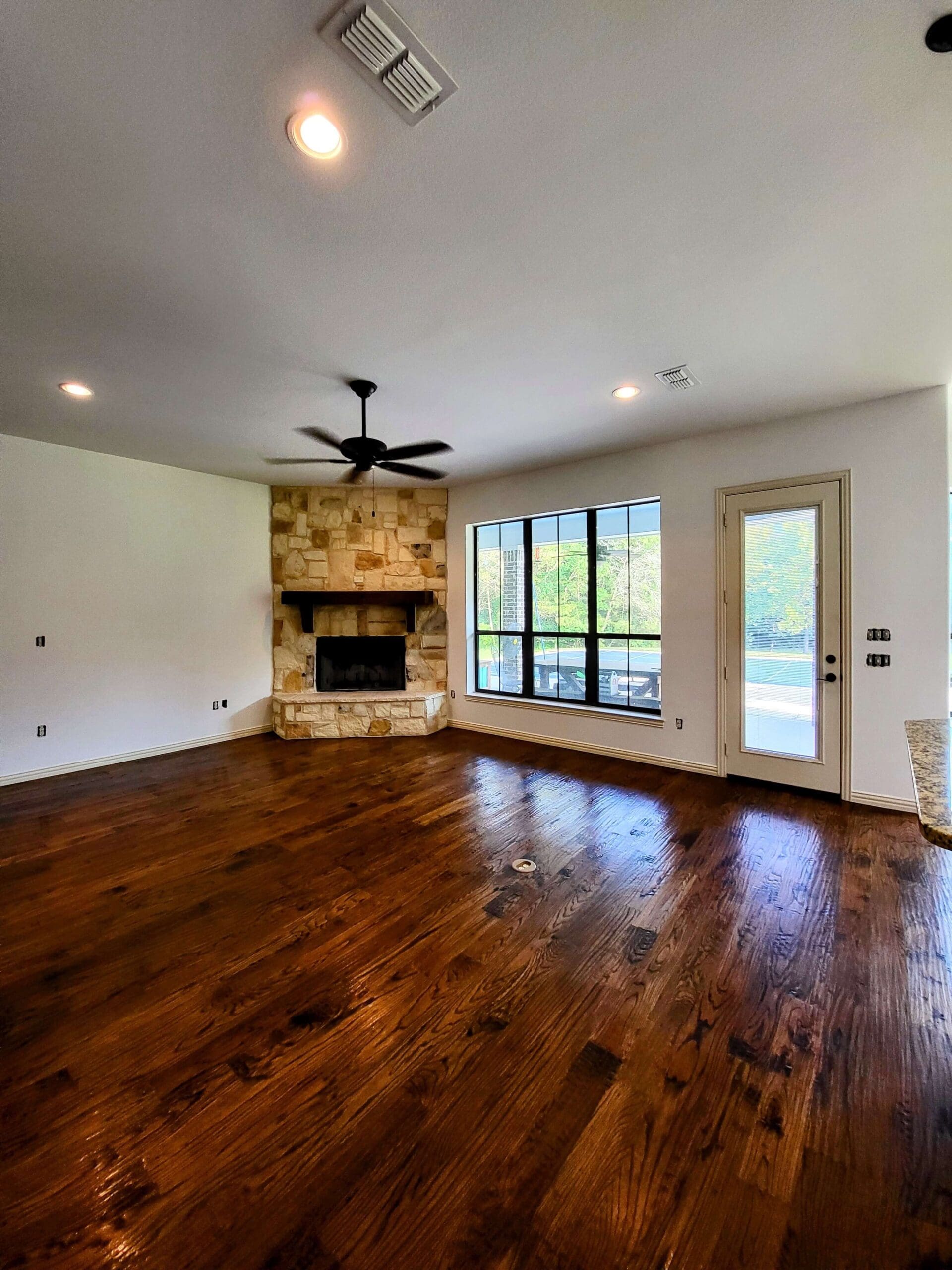 Spacious living room with hardwood floors and cozy fireplace.